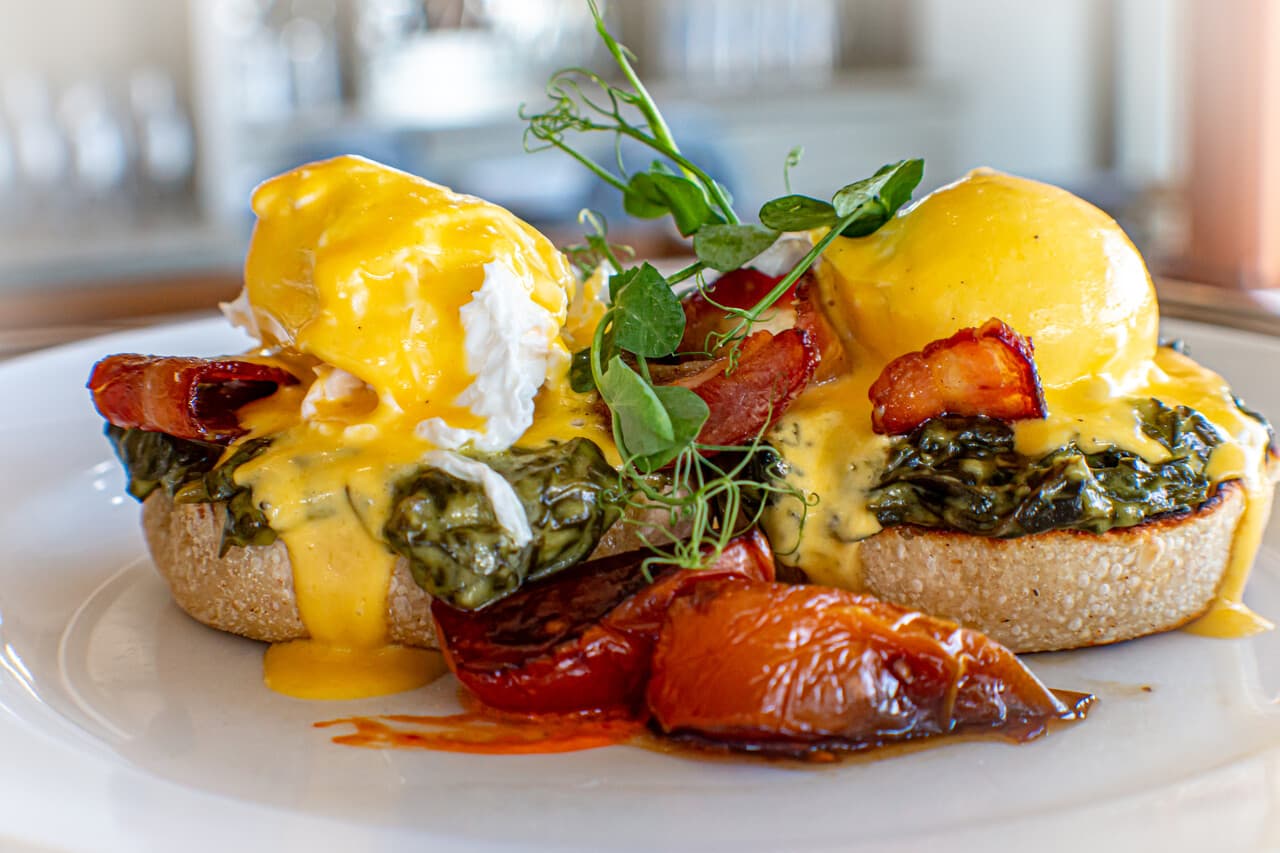 Eggs Benedict with creamed spinach, bacon and roast tomato at Blueberry Cafe