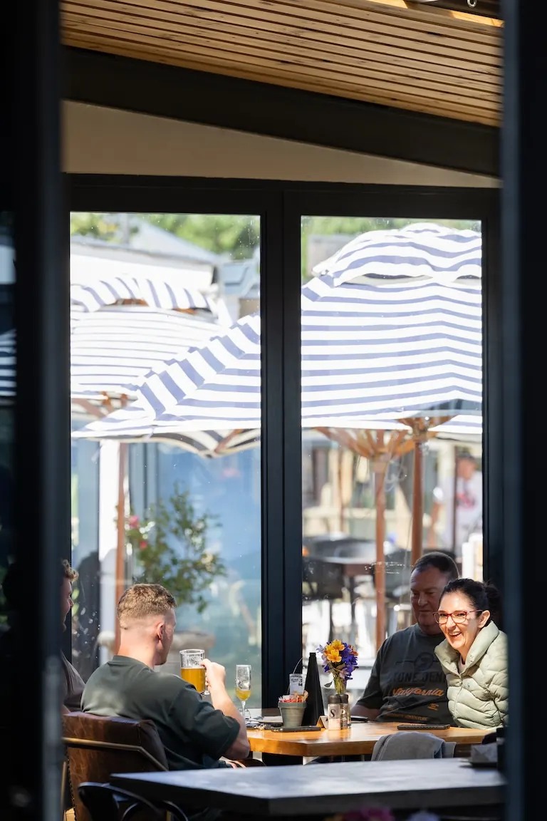 Guests under the striped umbrellas at Blueberry Brewery