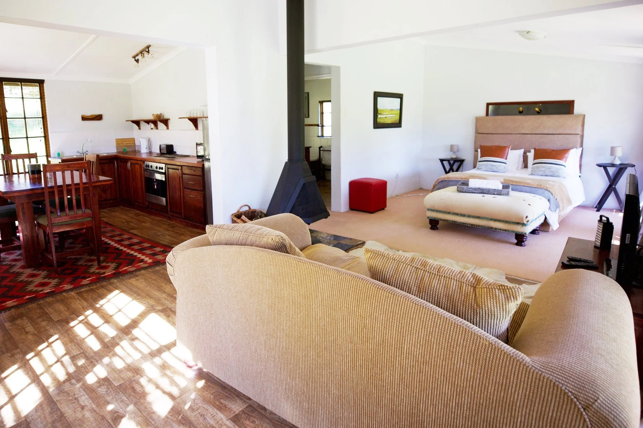 Open-plan queen bedroom, lounge and kitchen in Ankole Cottage