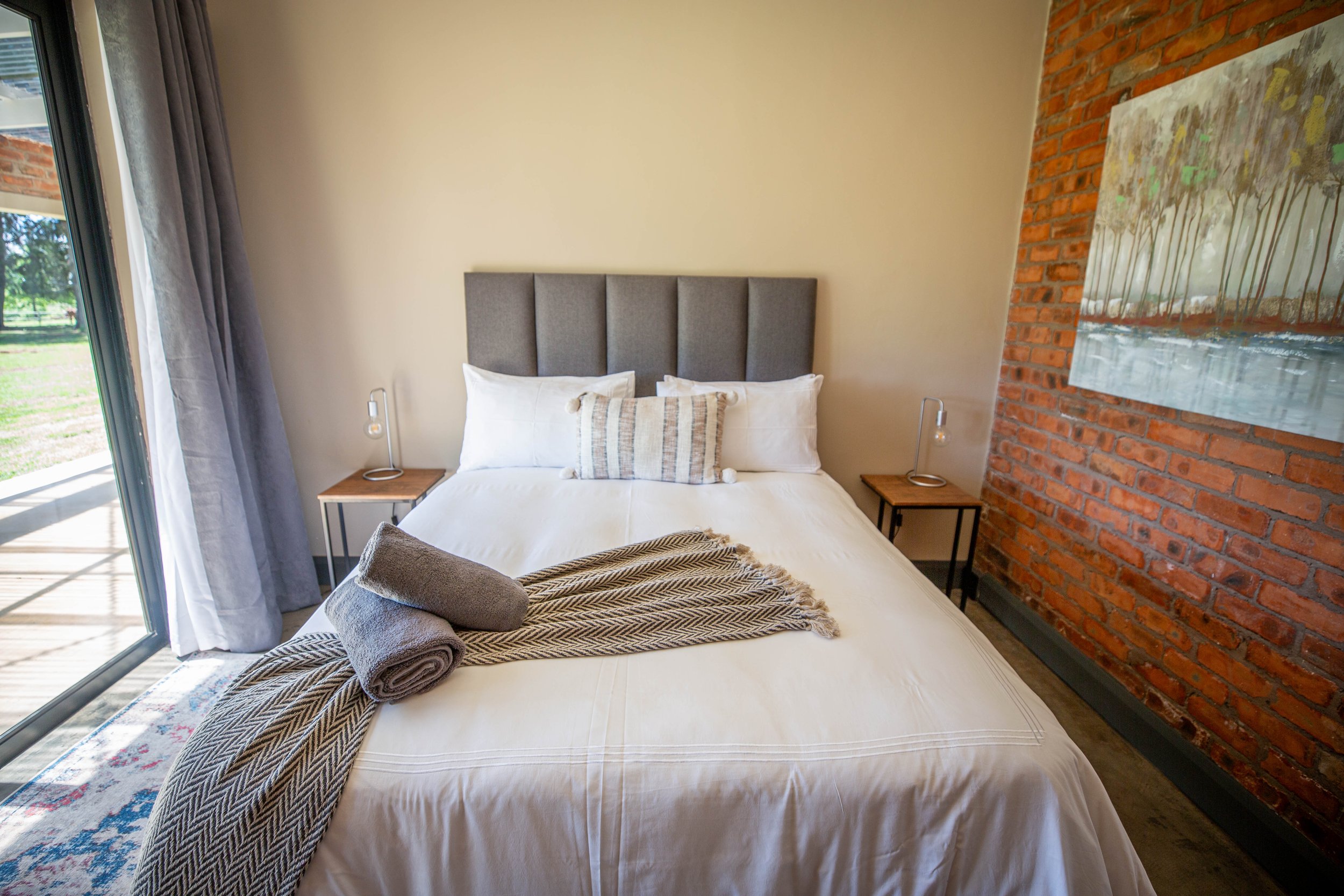 Queen bed and brick feature wall in Annex Room 2