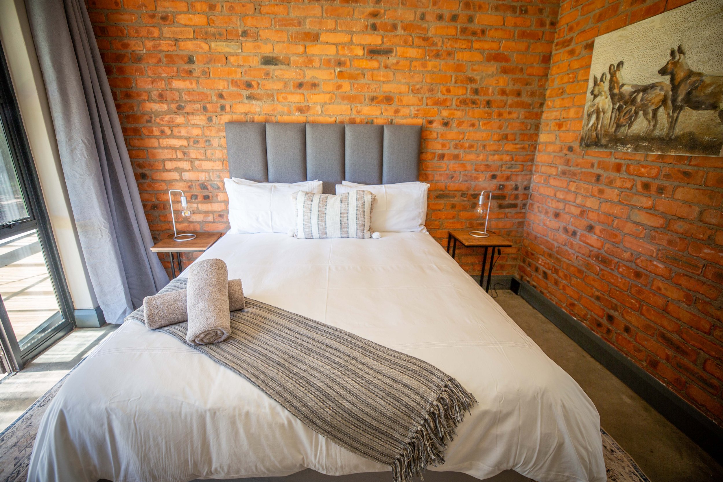 Queen bed against a full brick wall in Annex Room 5