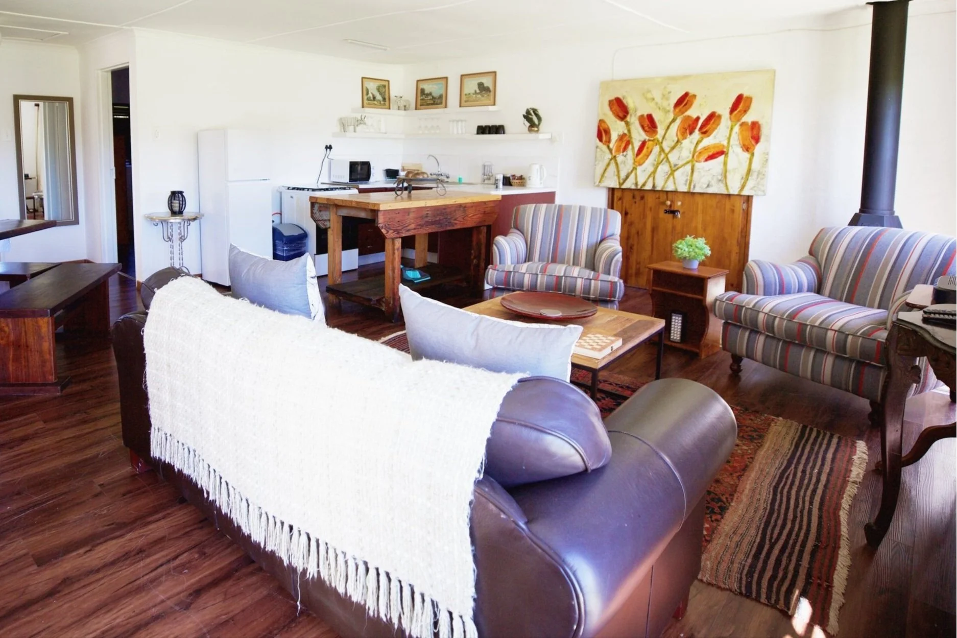 Open-plan lounge and kitchen with a wood stove in Duiker Cottage