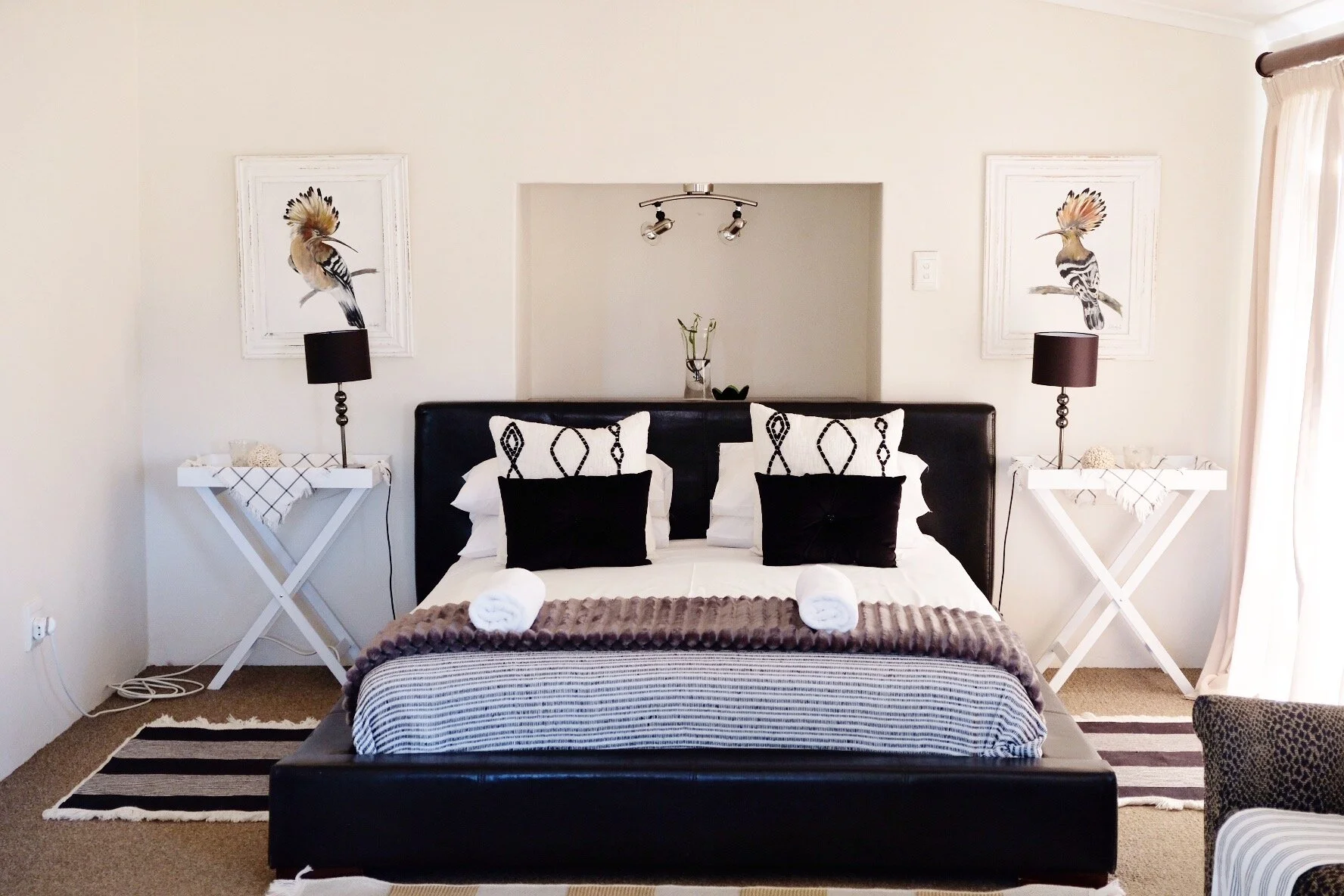 Queen bed with black and white styling in Eagle Cottage