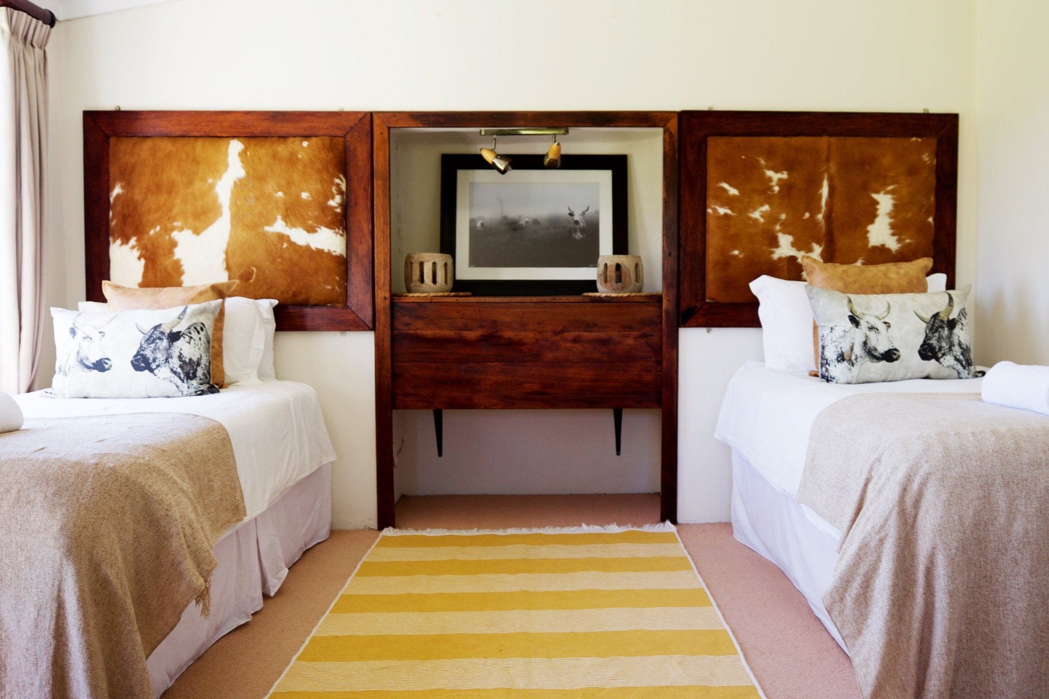 Twin beds with Nguni cowhide headboards in Nguni Cottage